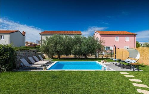 a swimming pool in a yard with chairs and a house at Villa Mediteranea in Umag