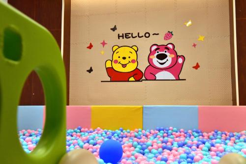 a wall with a winnie the pooh and a pile of balls at Crowne Plaza Shenzhen Futian, Near to Shenzhen Convention&Exhibition Centre, Shenzhen Stock Exchange and Shenzhen Civic Center, Outdoor Heated Pool in Shenzhen