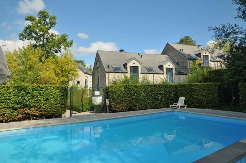 a swimming pool in front of a house at Résidence Durbuy in Durbuy