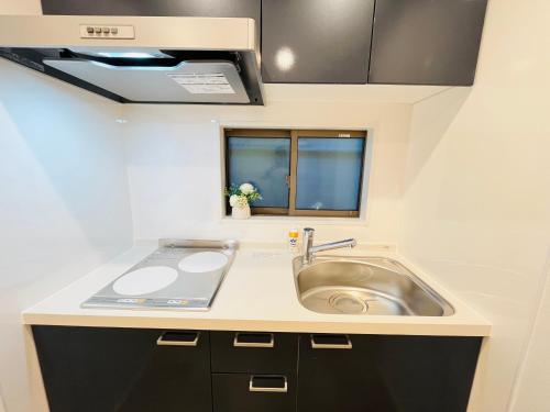 a small kitchen with a sink and a window at Year-end promotion Free Wi-Fi spacious and bright Closs Ueno 1min to Minowa Sta Wide Room Max 4People in Tokyo