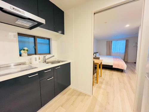 a kitchen with a sink and a room with a bed at Year-end promotion Free Wi-Fi spacious and bright Closs Ueno 1min to Minowa Sta Wide Room Max 4People in Tokyo