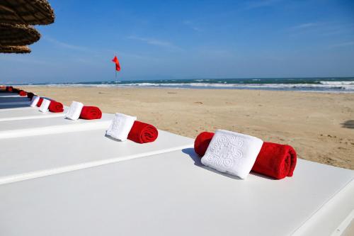 a row of white and red towels on a beach at Lantana Riverside Hoi An Boutique Hotel & Spa in Hoi An