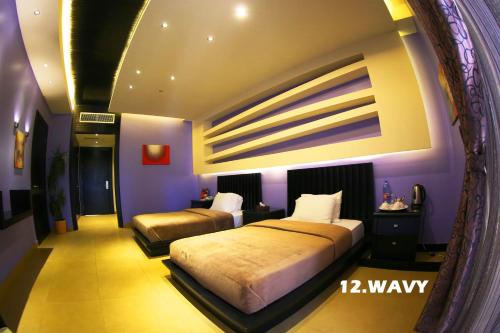 a bedroom with two beds in a room with purple walls at Layali Al Shams Hotel in ‘Anjar
