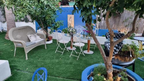 a garden with chairs and tables and a tree at Mike's House Jerusalem in Jerusalem