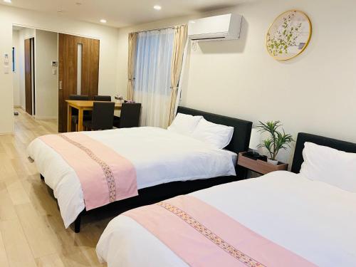 a hotel room with two beds and a table at Year-end promotion Free Wi-Fi spacious and bright Closs Ueno 1min to Minowa Sta Wide Room Max 4People in Tokyo