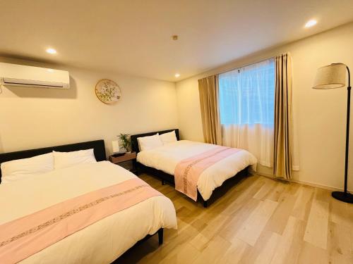 a hotel room with two beds and a window at Year-end promotion Free Wi-Fi spacious and bright Closs Ueno 1min to Minowa Sta Wide Room Max 4People in Tokyo