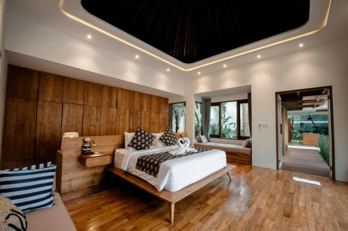 a bedroom with a large white bed and wooden walls at Seminyak Villa Paya paya Luxury near beach-Potato Head in Seminyak