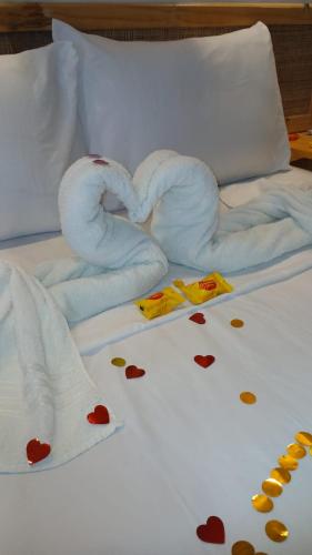 a bed with two towels and hearts on it at Pousada Solarium in Canoa Quebrada