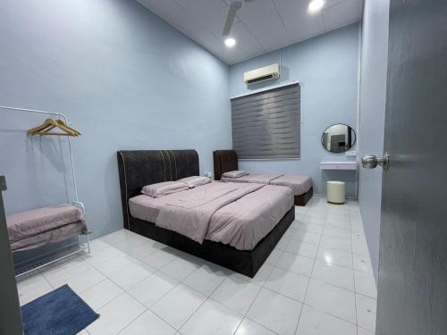 a bedroom with a bed in a blue wall at Cozy homestay in Mersing