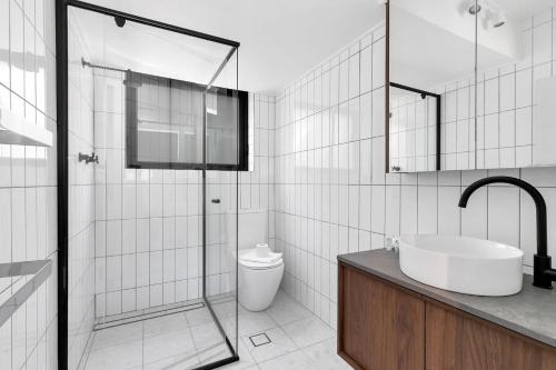 a white bathroom with a sink and a toilet at Byadbo 5 in Thredbo