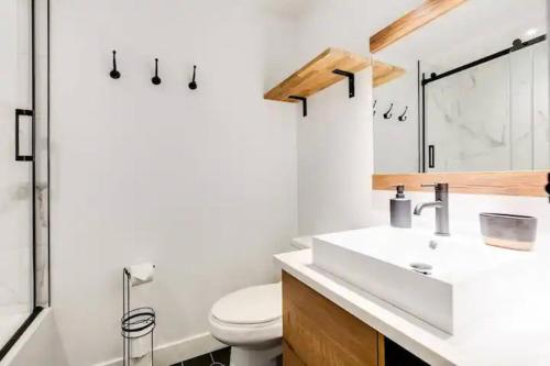 ein Badezimmer mit einem weißen Waschbecken und einer Toilette in der Unterkunft Condo moderne, escapade vacance, vue sur montagnes in Mont-Tremblant