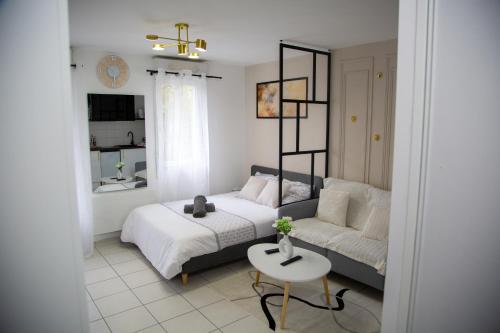 a bedroom with a bed and a couch and a table at Studio chic Nantes, calme assuré in Nantes