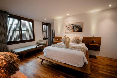 a bedroom with a bed and a bench in a room at Seminyak Villa Paya paya Luxury near beach-Potato Head in Seminyak