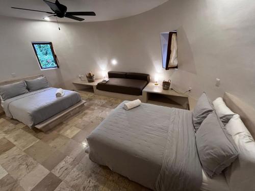 a bedroom with two beds and a couch at Villas Cononda in La Majahua