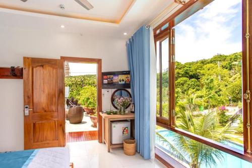 a bedroom with a large window with a view at Casare Phu Quoc - Formerly Caesar Hotel in Phu Quoc