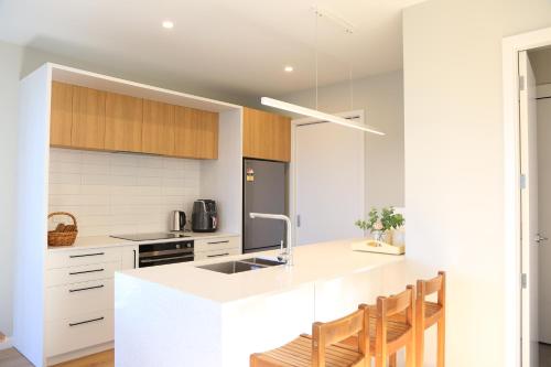 a kitchen with white countertops and wooden cabinets at Skyline Vista - Entirely New House with Luxe Views, Espresso, Netflix & Free Parking in Wellington