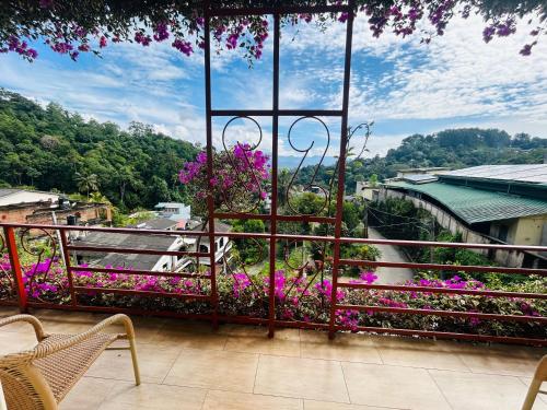 a balcony with purple flowers and a view of a bridge at Nature Walk Resort in Kandy