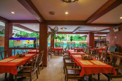 a restaurant with red tables and chairs and a pool at SK House 2 in Chiang Mai