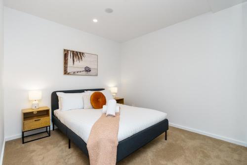 a small bedroom with a bed and a night stand at Serene 2BR Apt in the Radiant City of Civic - Hosted by Canstay in Canberra