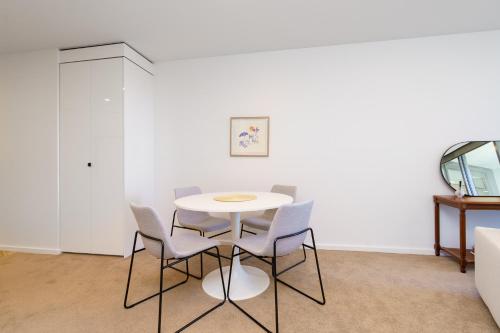 a white table and chairs in a room at Serene 2BR Apt in the Radiant City of Civic - Hosted by Canstay in Canberra