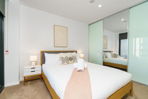 a bedroom with two beds and glass walls at Serene 2BR Apt in the Radiant City of Civic - Hosted by Canstay in Canberra
