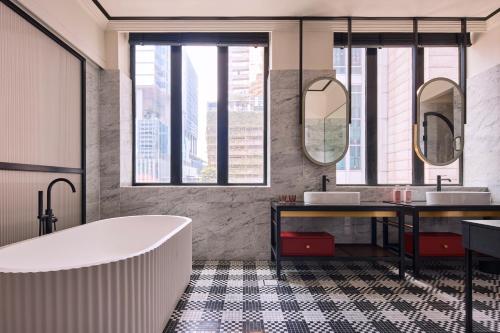 a bathroom with two sinks and a tub at QT Singapore in Singapore
