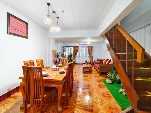 a dining room with a table and chairs and a staircase at Aphilapa House in Chiang Mai