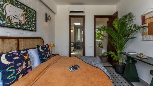 a bedroom with a bed and a plant at La Verona - 2,3,4 BHK Villas in Assagao with Private Pool, Garden, Caretaker, Kitchen & Security in Assagao