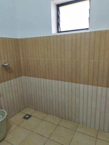 a bathroom with a shower stall with a window at Tropical Blooms by StayApart in Kutta