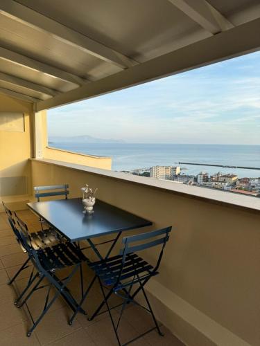 a table and chairs on a balcony with a view of the ocean at Formia Bellevue in Formia