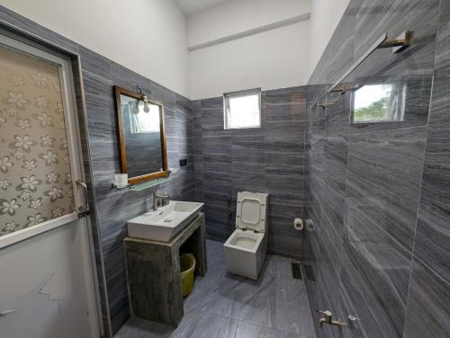 a bathroom with a toilet and a sink and a shower at Costels Mirissa in Mirissa