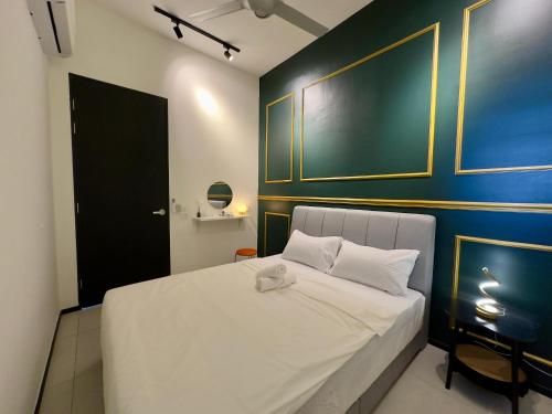 a bedroom with a white bed with a blue wall at Cozy Urban Suites Georgetown View in Jelutong