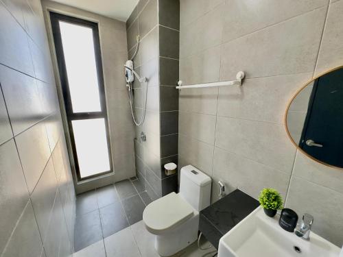 a bathroom with a toilet and a sink and a mirror at Cozy Urban Suites Georgetown View in Jelutong