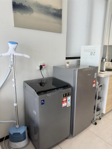 a kitchen with two refrigerators and a tripod in a room at Cozy Urban Suites Georgetown View in Jelutong