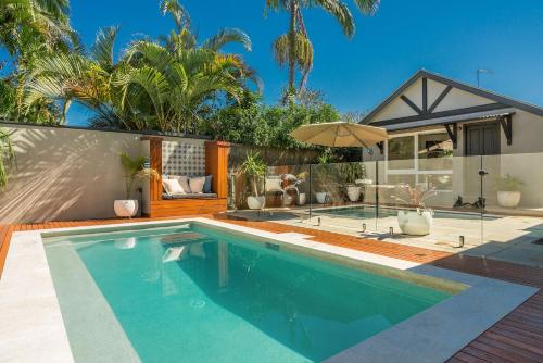 a swimming pool in front of a house at 3 Little Pigs in Byron Bay