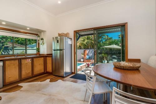 a kitchen with a table and a stainless steel refrigerator at 3 Little Pigs in Byron Bay