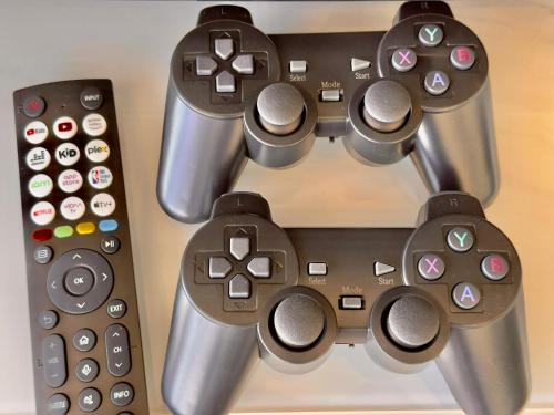 a group of remote controls sitting on a table at Cozy Urban Suites Georgetown View in Jelutong