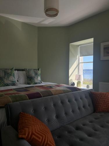 a bedroom with a large bed and a window at The Rhu Inn in Rhu