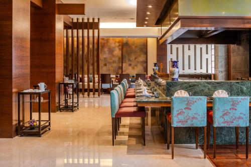 a dining room with a long table and chairs at Vivanta Goa, Panaji in Panaji