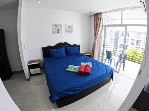 a bedroom with a bed with red shoes on it at At Seacondo-Studio-B26 in Klong Muang Beach