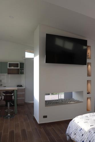 a room with a fireplace with a tv on a wall at Glamping en Hermosa Granja in Cogua
