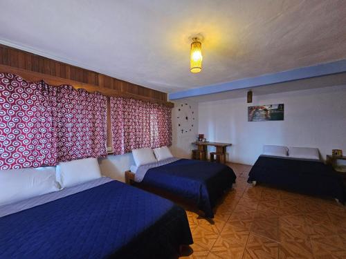 a hotel room with two beds and a window at Hotel Colonial Campestre in UniÃ³n JuÃ¡rez