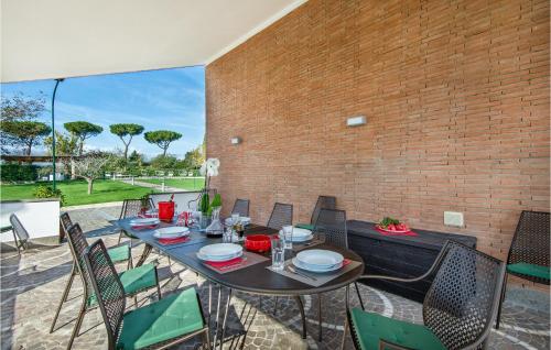 un patio con tavolo, sedie e muro di mattoni di Lovely Home In Anguillara Sabazia a Anguillara Sabazia