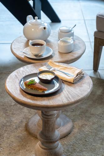 a table with two plates of food and a tea pot at Villa Thuya in Balapitiya