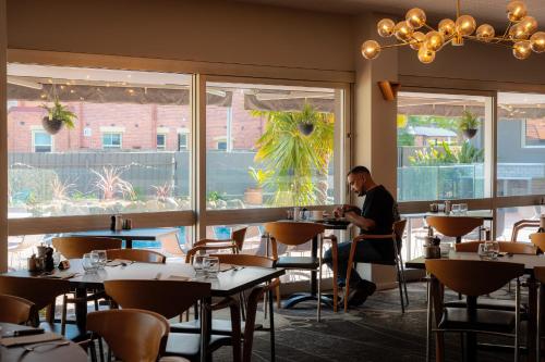 a man sitting at a table in a restaurant at Mercure Albury in Albury