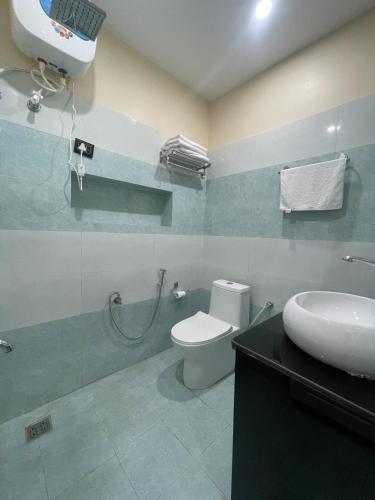 a bathroom with a shower and a toilet and a sink at Hotel Happy Home in Bhairāhawā