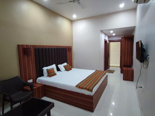 a bedroom with a bed and a chair and a television at Mishka Boutique Hotel in Rāmgarh