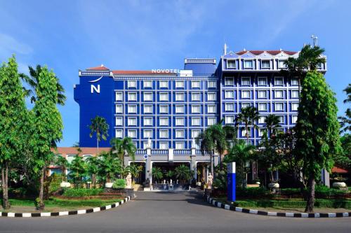 a large hotel with a blue building at Novotel Solo in Solo