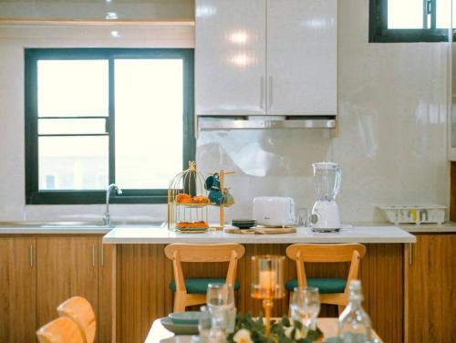a kitchen with a table with two chairs and a counter at Click Residence, Si Muang in Vientiane