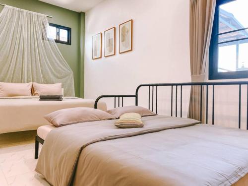 two beds in a room with green and white at Click Residence, Si Muang in Vientiane